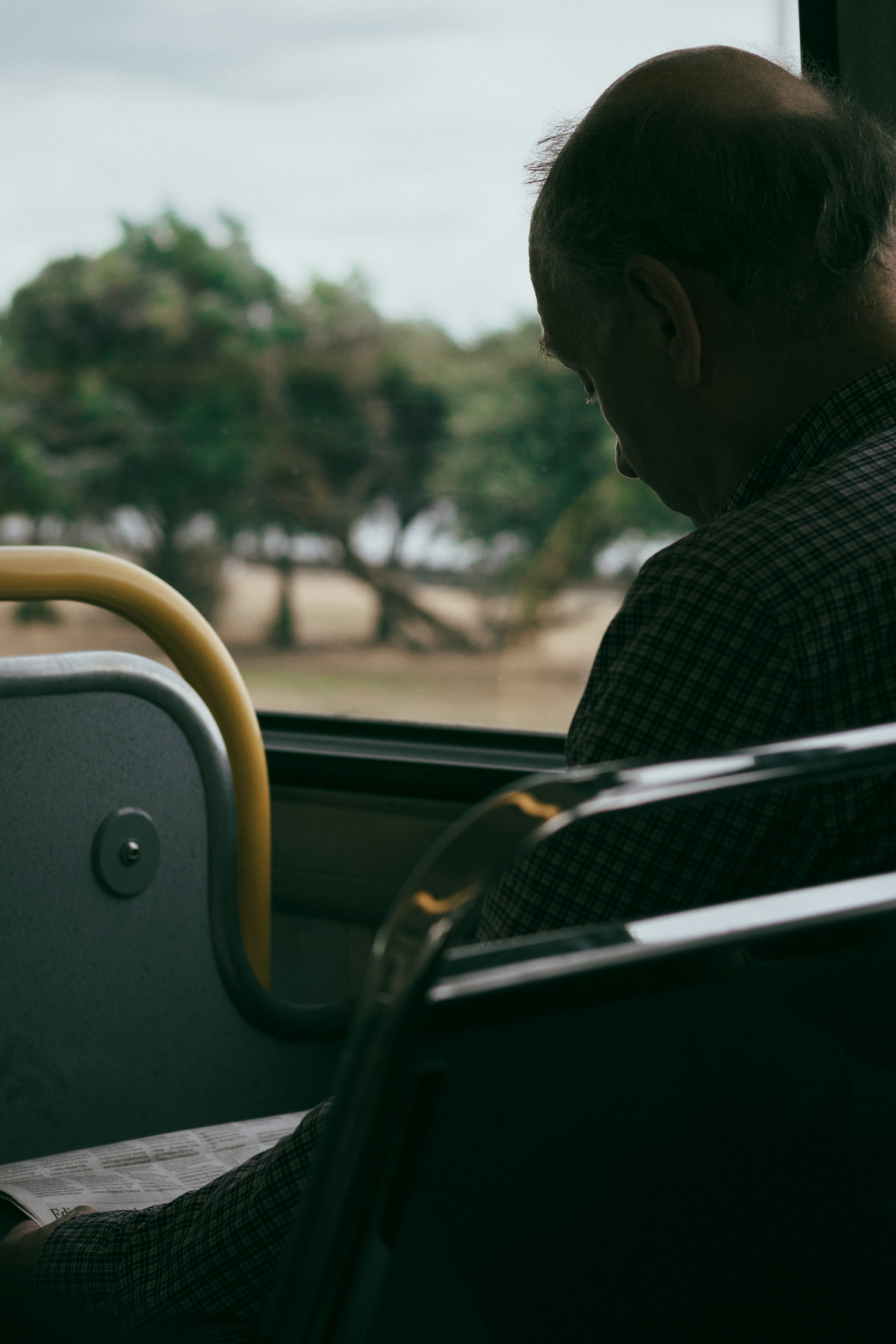 man sitting on passenger seat reading on newspaper